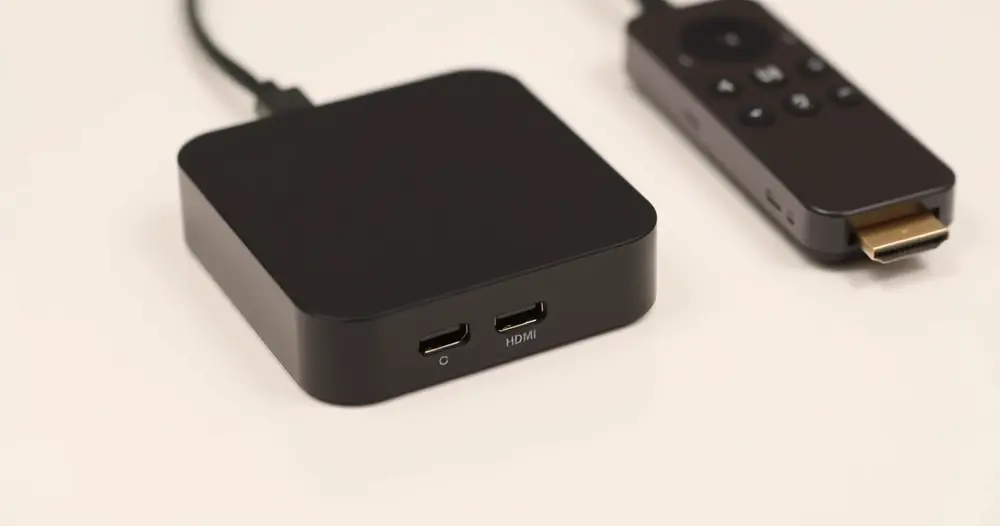 aparelho de streaming e cabo hdmi sobre superfície branca